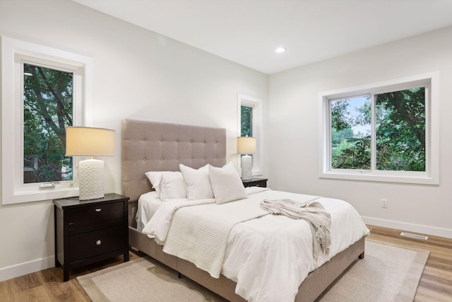 bedroom featuring light hardwood / wood-style floors and multiple windows