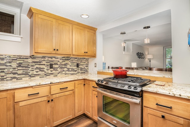 kitchen featuring stainless steel gas stove, hanging light fixtures, light stone counters, kitchen peninsula, and decorative backsplash