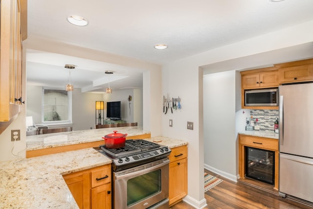 kitchen featuring light stone countertops, dark hardwood / wood-style flooring, tasteful backsplash, stainless steel appliances, and hanging light fixtures