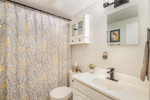 bathroom featuring vanity, a textured ceiling, and toilet