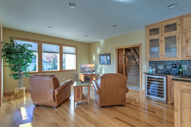 living room featuring light wood-type flooring, wine cooler, and indoor bar