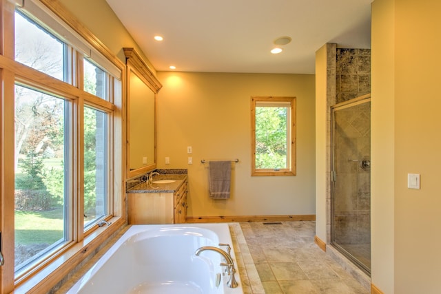 bathroom with plus walk in shower, vanity, and plenty of natural light