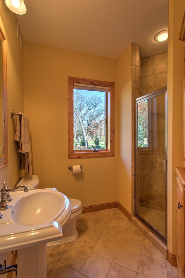 bathroom with sink, walk in shower, tile patterned floors, a textured ceiling, and toilet