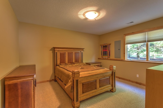 carpeted bedroom with a textured ceiling and electric panel