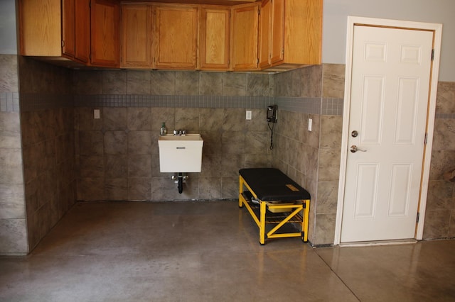 interior space featuring tile walls and sink