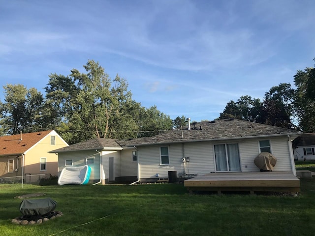 rear view of house with a lawn, fence, and a wooden deck