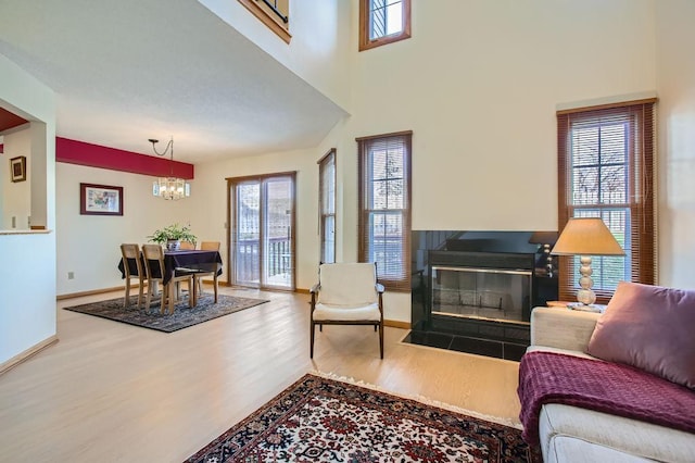 living room with hardwood / wood-style flooring, a high ceiling, and an inviting chandelier