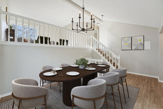 dining area with an inviting chandelier, hardwood / wood-style flooring, and high vaulted ceiling