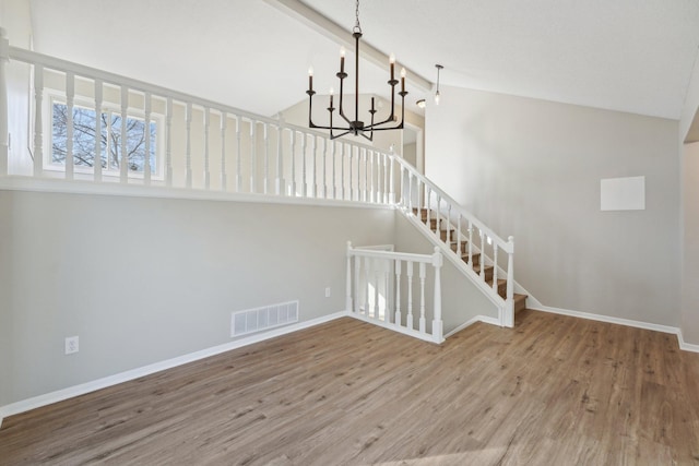 stairs featuring hardwood / wood-style flooring, beam ceiling, high vaulted ceiling, and a chandelier