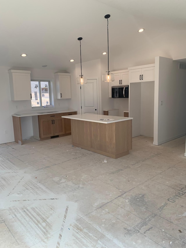 kitchen featuring a large island, decorative light fixtures, and white cabinets