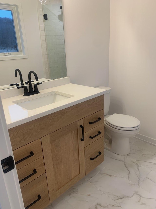 full bath with vanity, baseboards, a tile shower, toilet, and marble finish floor