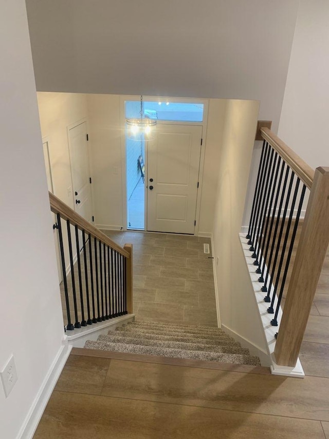 entrance foyer with stairs, wood finished floors, and baseboards