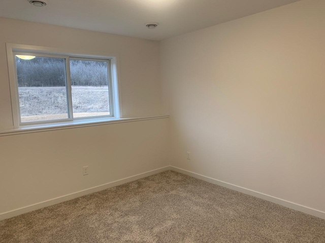 carpeted empty room featuring visible vents and baseboards