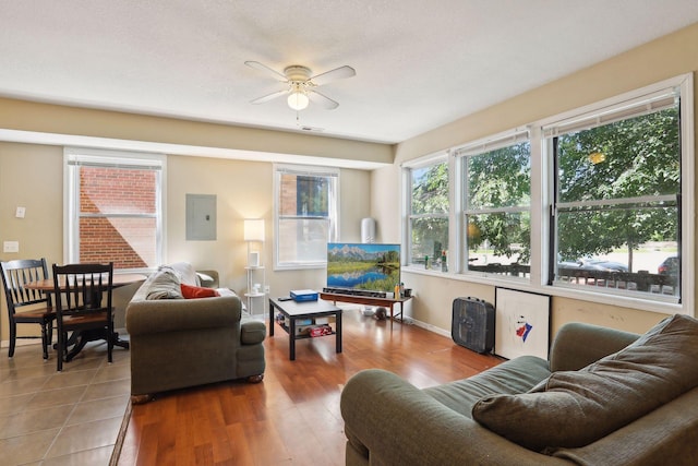 living room with hardwood / wood-style flooring, ceiling fan, and electric panel