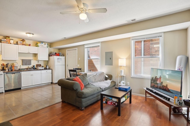 living room featuring electric panel, ceiling fan, light hardwood / wood-style flooring, and sink