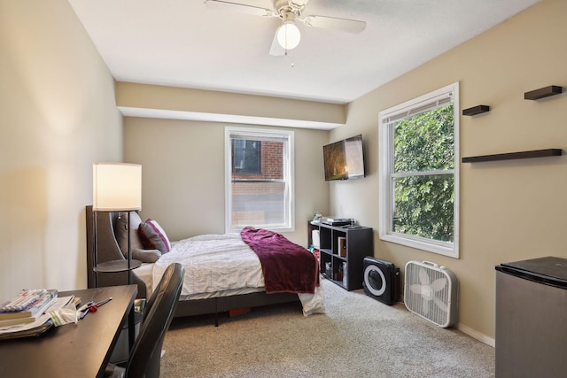 bedroom featuring stainless steel fridge, ceiling fan, and light colored carpet