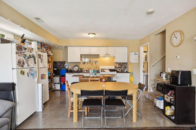 tiled dining area with a textured ceiling