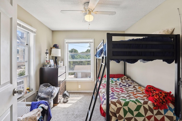 bedroom featuring carpet flooring, ceiling fan, and a textured ceiling