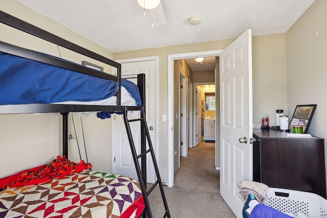 carpeted bedroom featuring a textured ceiling and ceiling fan