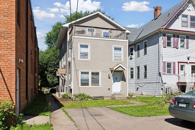 view of front of home featuring a balcony and a front lawn