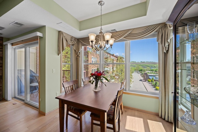 630 Main St N Unit 202, Stillwater, MN 55082 - dining room featuring a chandelier, light wood-style flooring, baseboards, and healthy amount of natural light
