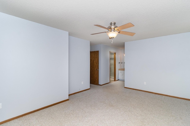 empty room with ceiling fan, a textured ceiling, and carpet flooring