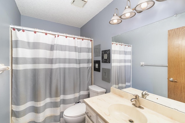 bathroom featuring a textured ceiling, toilet, and vanity