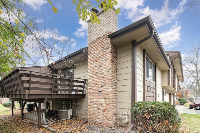 view of side of property with a balcony, cooling unit, and a garage