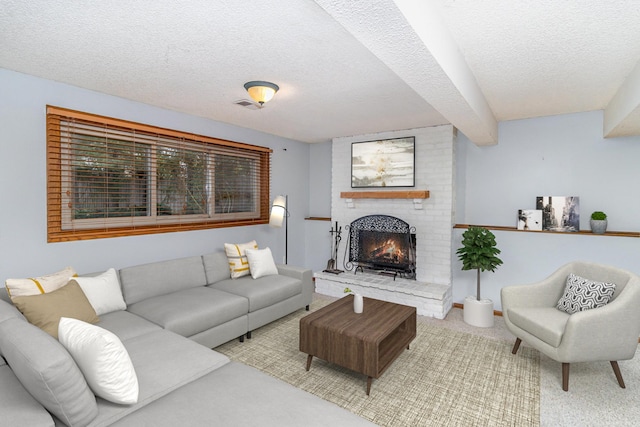 living room with a fireplace, beamed ceiling, and a textured ceiling