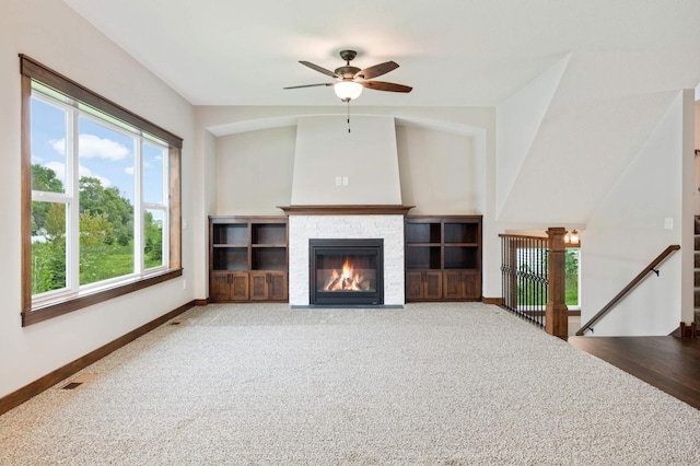 unfurnished living room featuring a fireplace, carpet floors, ceiling fan, and lofted ceiling