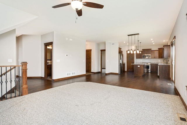 living room featuring ceiling fan, sink, and dark wood-type flooring