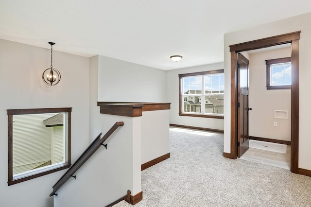 interior space featuring light carpet and a chandelier