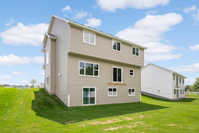 rear view of property featuring a lawn