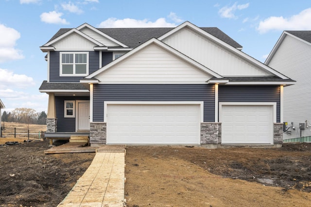 craftsman house featuring driveway, a shingled roof, an attached garage, and fence