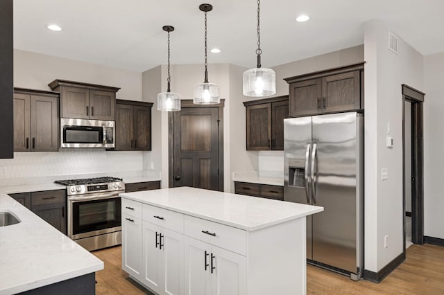 kitchen featuring dark brown cabinets, appliances with stainless steel finishes, light wood-style flooring, and visible vents