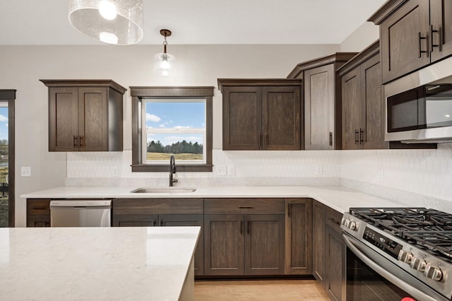 kitchen featuring decorative backsplash, appliances with stainless steel finishes, dark brown cabinets, and a sink