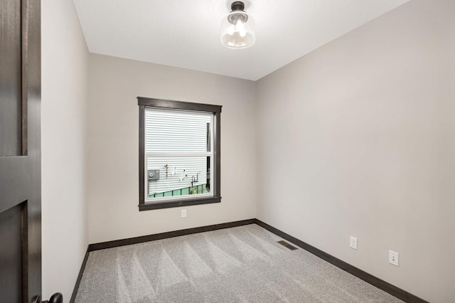 carpeted spare room with visible vents and baseboards