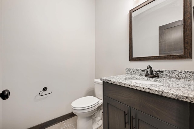 bathroom with baseboards, vanity, toilet, and tile patterned floors