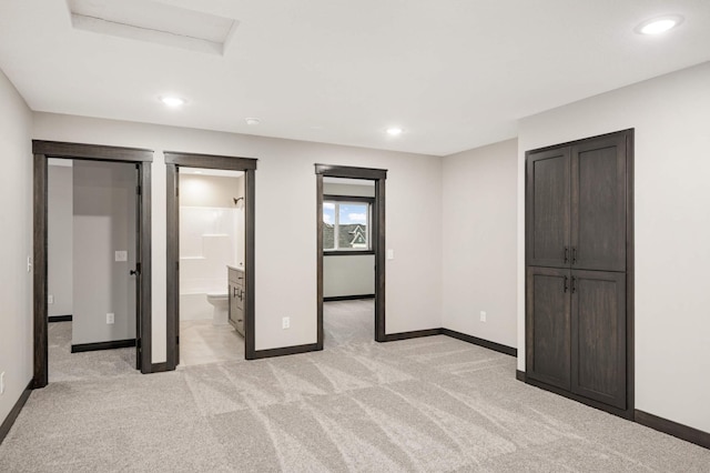 unfurnished bedroom featuring light carpet, a closet, recessed lighting, and baseboards