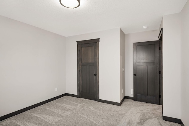 unfurnished bedroom featuring carpet and baseboards