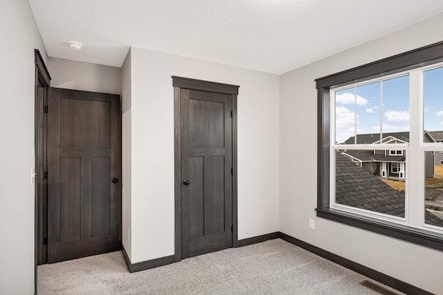 bedroom featuring light colored carpet, visible vents, and baseboards