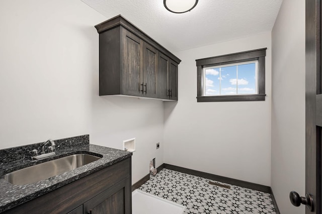 laundry room featuring cabinet space, baseboards, electric dryer hookup, a textured ceiling, and a sink