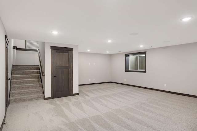 finished basement with light carpet, stairway, recessed lighting, and baseboards