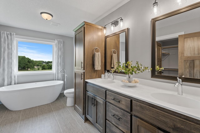 bathroom featuring a tub, vanity, and toilet