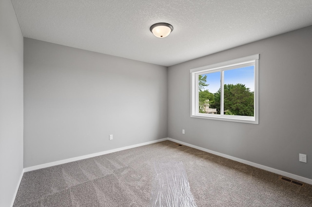 unfurnished room featuring carpet flooring and a textured ceiling