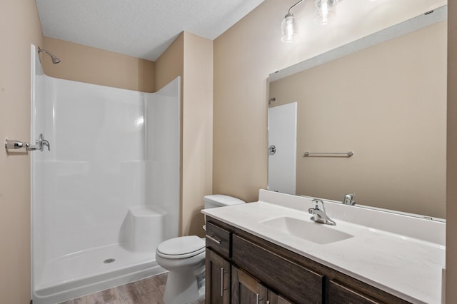 bathroom featuring a shower, hardwood / wood-style floors, a textured ceiling, toilet, and vanity