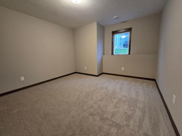 spare room with light carpet and a textured ceiling