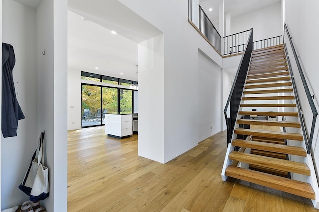 stairway featuring hardwood / wood-style flooring, expansive windows, and a towering ceiling