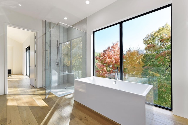 bathroom featuring hardwood / wood-style flooring and shower with separate bathtub