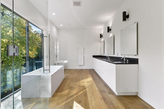 bathroom featuring vanity, a tub, and hardwood / wood-style floors